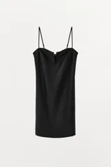 Vestido corto negro confeccionado en hilatura con poliamida. Presenta escote corazón con pieza metálica forrada en el pecho y tirantes finos ajustables.