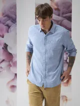 Camisa celeste a cuadros blancos, de manga larga y corte recto.