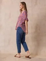 Blusa de gasa estampada con cuello a la base, abertura central con botones y mangas cortas con volados.