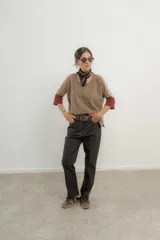 Pantalón de jean de tiro alto color gris oscuro, corte recto, con cinturón de cuero marrón y pañuelo estampado atado al cuello.