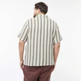 Camisa de manga corta con rayas verticales color crema y gris. Tiene cuello clásico y cierre frontal con botones.