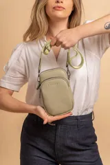 Bandolera compacta color verde oliva, con dos compartimentos frontales con cierre y correa regulable y desmontable. Presenta el logo grabado en el frente.