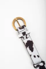 Cinto de cuero con estampado de vaca y hebilla dorada.