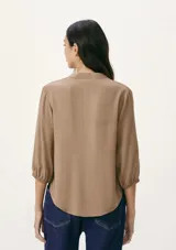 Blusa color verde claro, de mangas 3/4 con elástico en los puños, escote en V con botones y corte holgado.