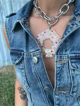 Collar con cadena gruesa plateada y dije abstracto desmontable de acrílico y resina con incrustaciones de strass de colores.