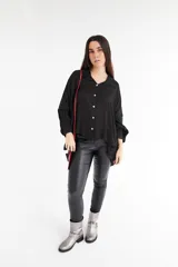 Camisa color beige de satén con corte holgado, cuello camisero y mangas largas con puños abotonados.