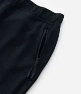 Pantalón deportivo negro de tela texturizada, con cintura elástica y bolsillos con cierre.