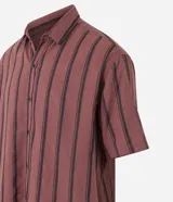 Camisa masculina de corte relajado, confeccionada en cáñamo, algodón y poliéster. Presenta cuello inglés, mangas cortas y rayas verticales texturizadas.