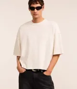 Remera oversized de algodón color crudo, con cuello redondo, manga corta, sin estampa y ribete acanalado.