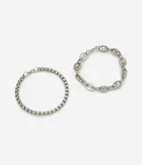 Kit de dos pulseras de metal plateado. Una es una cadena de eslabones cuadrados (tipo caja) y la otra es una cadena de eslabones ovales alargados (tipo grano de café o cerdito).