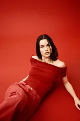 Top rojo de punto elástico con hombros descubiertos, escote ancho con doblez y laterales fruncidos.