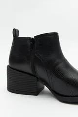 Botineta negra de símil cuero con punta fina y taco ancho de 6cm de alto.