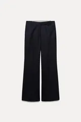 Pantalón de vestir de lana color azul marino, de tiro medio, con trabillas en la cintura, bolsillos frontales, pinzas delanteras y pierna recta.
