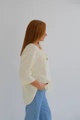 Blusa color amarillo pálido de corte holgado, con escote en V y mangas 3/4.