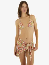 Minifalda de playa con estampado floral multicolor, con volantes en el ruedo y cierre frontal con nudo.