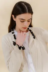 Saco tejido azul marino con cuello redondo, cierre frontal con botones y detalle de volados en cuello y puños.