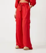 Conjunto de top corto con escote en V y mangas abullonadas, y pantalón palazzo con bolsillos cargo y lazo en la cintura, ambos en color rojo.