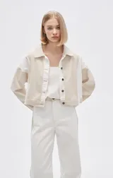 Campera corta de algodón color beige con detalles en blanco, de manga larga y cierre frontal con botones.