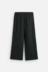 Pantalón negro de corte amplio con cintura elástica ajustable con cordón, bolsillos delanteros y detalle de bolsillo trasero de vivo.