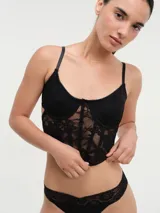 Corset negro de encaje con copas preformadas y breteles finos regulables.
