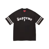 Camiseta negra de corte estándar con el logo de Supreme en tipografía gótica blanca y mangas cortas con dos franjas horizontales grises.