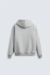 Sudadera con capucha color crudo, de corte relajado, confeccionada en tejido de algodón con interior rizado. Cuenta con cuello con capucha, manga larga, bolsillo frontal tipo canguro y acabados en rib.