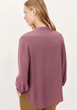 Blusa color verde claro, de mangas 3/4 con elástico en los puños, escote en V con botones y corte holgado.