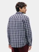 Camisa de manga larga con estampado a cuadros vichy en tonos azul marino y blanco. Presenta cuello camisero y botones frontales.