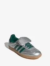 Zapatillas Adidas Samba LT plateadas con detalles en verde oscuro, suela de goma color caramelo y lengüeta plateada.