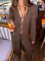 Saco largo de tejido de punto negro, con diseño acordonado en el frente y mangas largas.