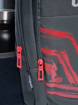 Mochila Umbro modelo Bloop, color gris oscuro con estampado frontal en rojo y detalles en rojo en las cremalleras. Posee bolsillo lateral de malla para botella y logo Umbro plateado en la parte superior.