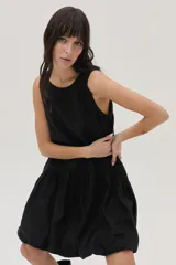 Vestido corto negro de lino, corte evasé, sin mangas y con escote redondo.