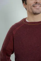 Sweater marrón de lana lambswool con cuello redondo y mangas largas. Presenta un diseño de punto texturizado en el cuerpo y mangas con detalle de punto acanalado en hombros y puños.