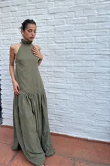 Vestido largo verde oliva de tela simil agamuzada, con escote halter, espalda baja y volados en cuello y cadera.