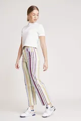 Pantalón jean de corte wide leg con estampado de rayas verticales en tonos lila, verde y amarillo.