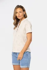 Camisa beige con estampado floral, de manga corta y cuello camisero con botones.