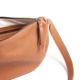 Cartera bandolera de cuero graneado color marrón, con correa ajustable que rodea toda la cartera. Tiene forma de media luna con bordes redondeados y logo Loria Studio grabado en el frente. Interior forrado en algodón.