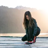 Campera cortaviento gris con estampado camuflado, cierre frontal completo, capucha ajustable y logo de la marca en el pecho.