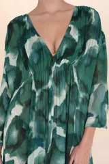 Kaftán largo de tela ligera y semitransparente con estampado abstracto en tonos verdes y azules. Presenta escote en V con frunces en el busto y mangas amplias.