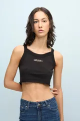 Musculosa corta negra de jersey pima de algodón peruano, de calce ajustado y escote en U. Presenta estampa metálica frontal con la palabra Ginebra.