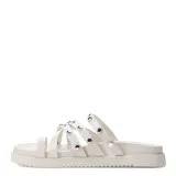 Sandalias bajas color blanco con tiras finas y tachas plateadas.