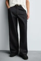 Pantalón de jean negro de corte amplio, con bolsillos delanteros y traseros, presilla portaherramientas en la pierna derecha y costuras a contratono.