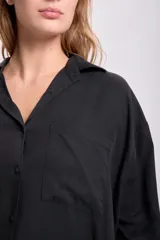 Camisa negra de lyocell con cuello clásico, cierre frontal con botones, manga larga y bolsillo en el pecho.