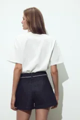Camiseta blanca de cuello redondo y manga corta con detalle de flores con volumen en delantero a tono.