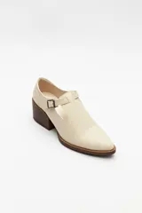 Zapato tipo T-bar de charol negro con hebilla lateral y taco ancho.