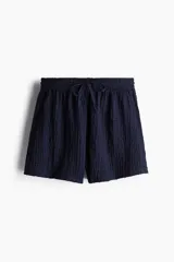 Short azul marino de punto arrugado con cintura elástica y cordón ajustable.