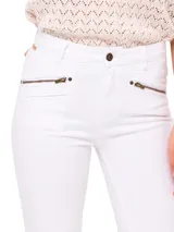 Pantalón de jeans blanco, corte skinny, tiro medio, con bolsillos delanteros con cierre metálico color bronce y ruedo desflecado.