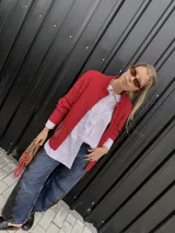 Campera tejida con textura vanizada a rayas horizontales en blanco y negro, con cierre frontal y flecos negros en forma de V en el pecho.