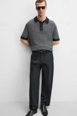 Polo de punto de algodón a rayas verticales en tonos azul marino y gris. Tiene cuello clásico, tapeta con botones y corte recto.