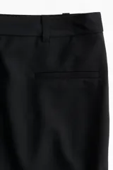 Minifalda negra de sarga con corte sastrero, bolsillos insertados en el frente, bajo recto y forro interno.